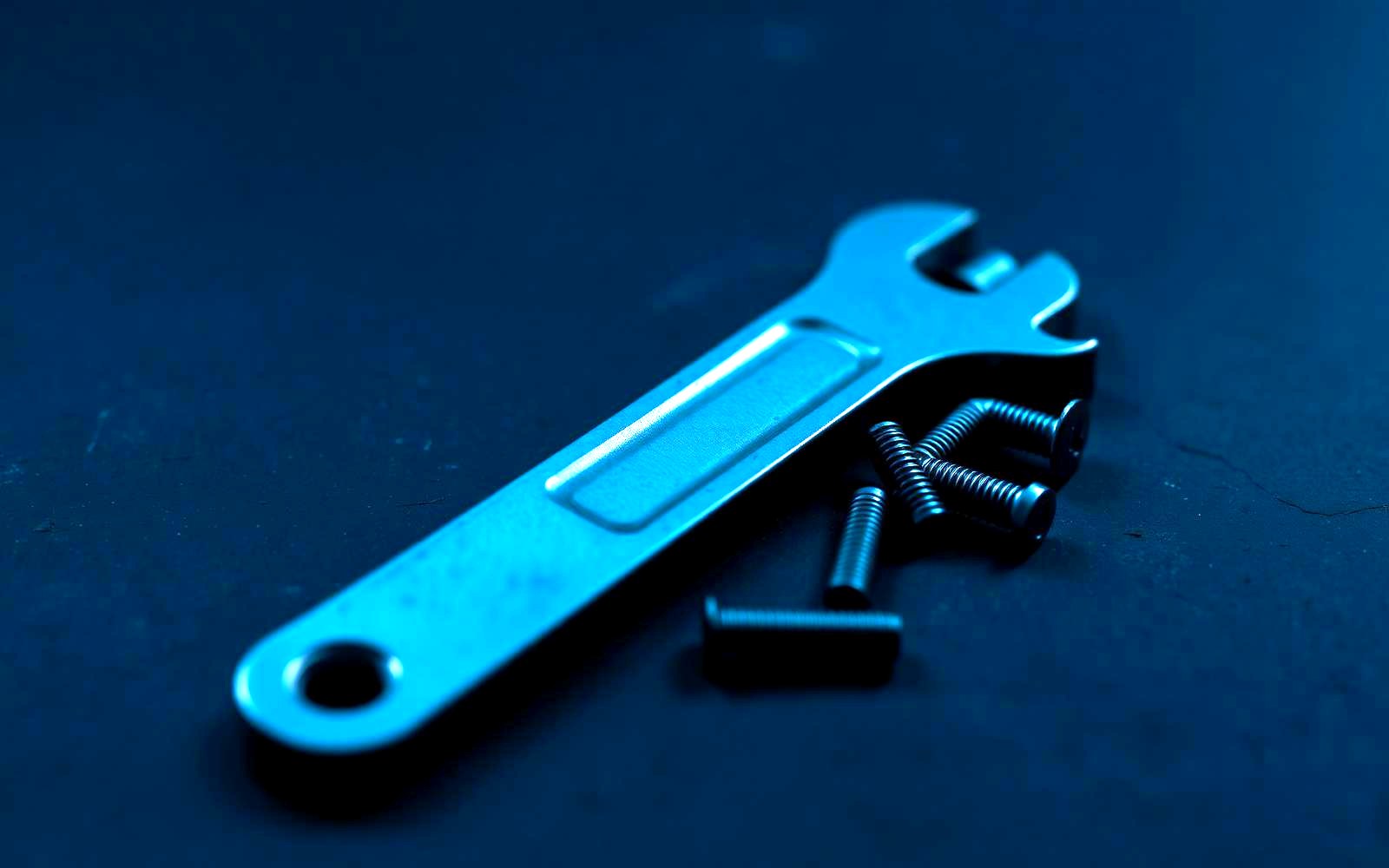 Hand tools and fasteners on a dark work surface
